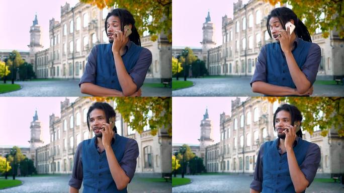 迷人的非裔美国学生的肖像，在大学背景下，长发lock在手机上进行情感交谈。