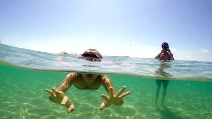 带着浮潜面具的夫妇在暑假在绿松石清水潜水时玩得开心，gopro圆顶拍摄