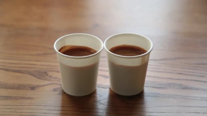 木桌上放两杯浓浓的浓缩咖啡