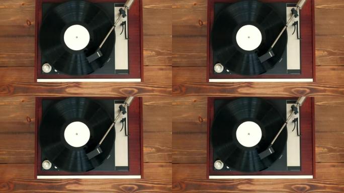 俯视图-老式好看的转盘在木制背景上播放带有乙烯基的音乐。4k Uhd。