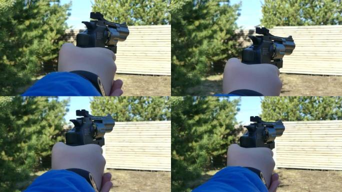 一个拿着枪的少年暗示了一个目标。少女射击气动手枪。手握气动左轮手枪。特写。