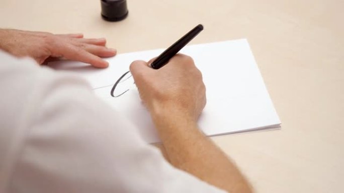 艺术家在白色空白上写信。近距离拍摄。顶视图。毛笔书法刻字。男人在白色空白上画画。书法家写作。选择性软