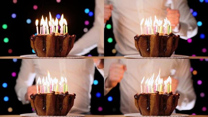 快乐的人在生日派对上跳舞，在美味的巧克力蛋糕前，蛋糕上点着五颜六色的蜡烛