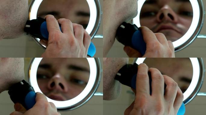 男人用电动剃须刀刮脸，在浴室里照镜子。
