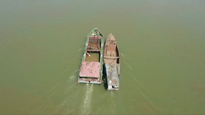 高架跟踪无人机拍摄了一艘古老的挖泥驳船并排在河上