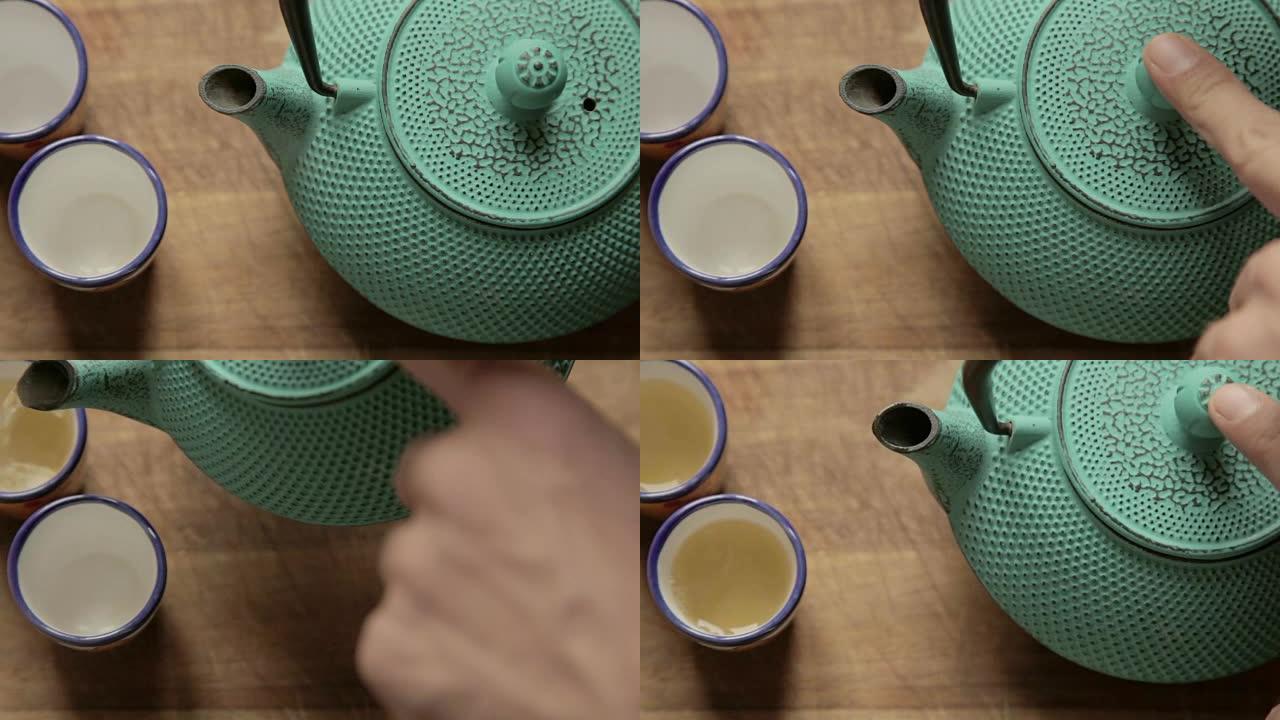 人手用盖子合上茶叶柜，然后将热茶放到两个陶瓷杯上