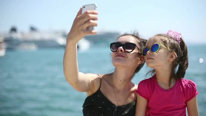 母亲和女儿在亚得里亚海旁拍照