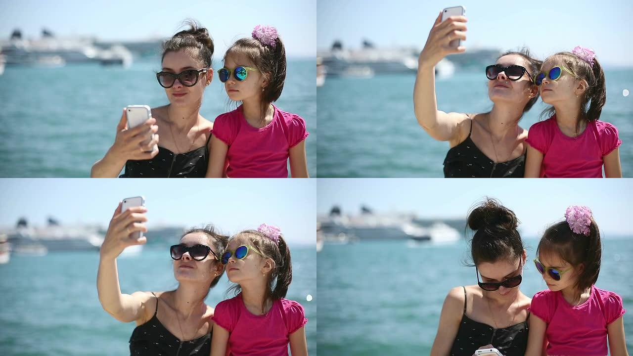 母亲和女儿在亚得里亚海旁拍照