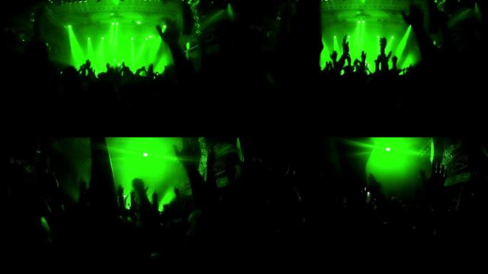 绿色闪烁: 摇滚音乐会上欢呼人群的实时视频放慢了一秒钟，然后恢复