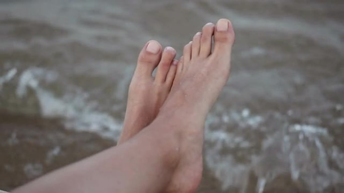 女性的腿靠海