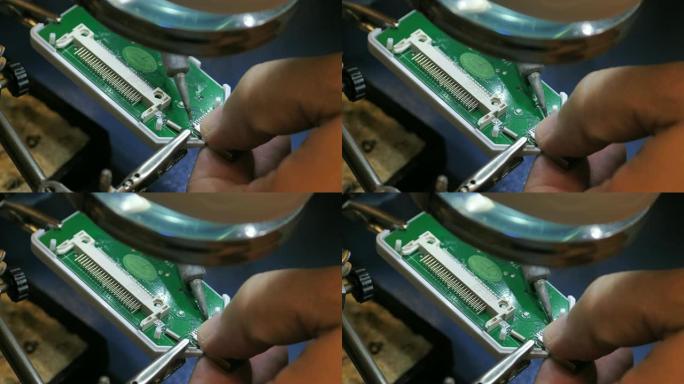 在服务店中，一个人在损坏的USB设备上焊接引脚的特写镜头