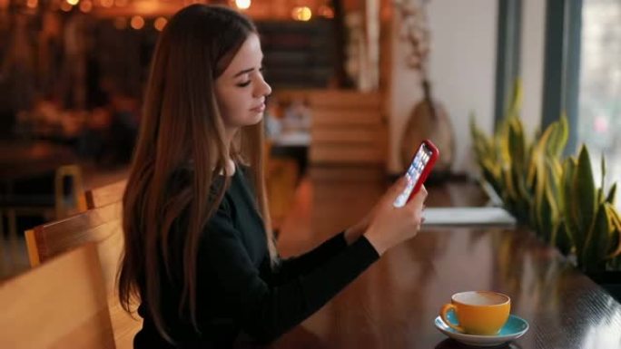 女人坐在咖啡馆里用智能手机自拍