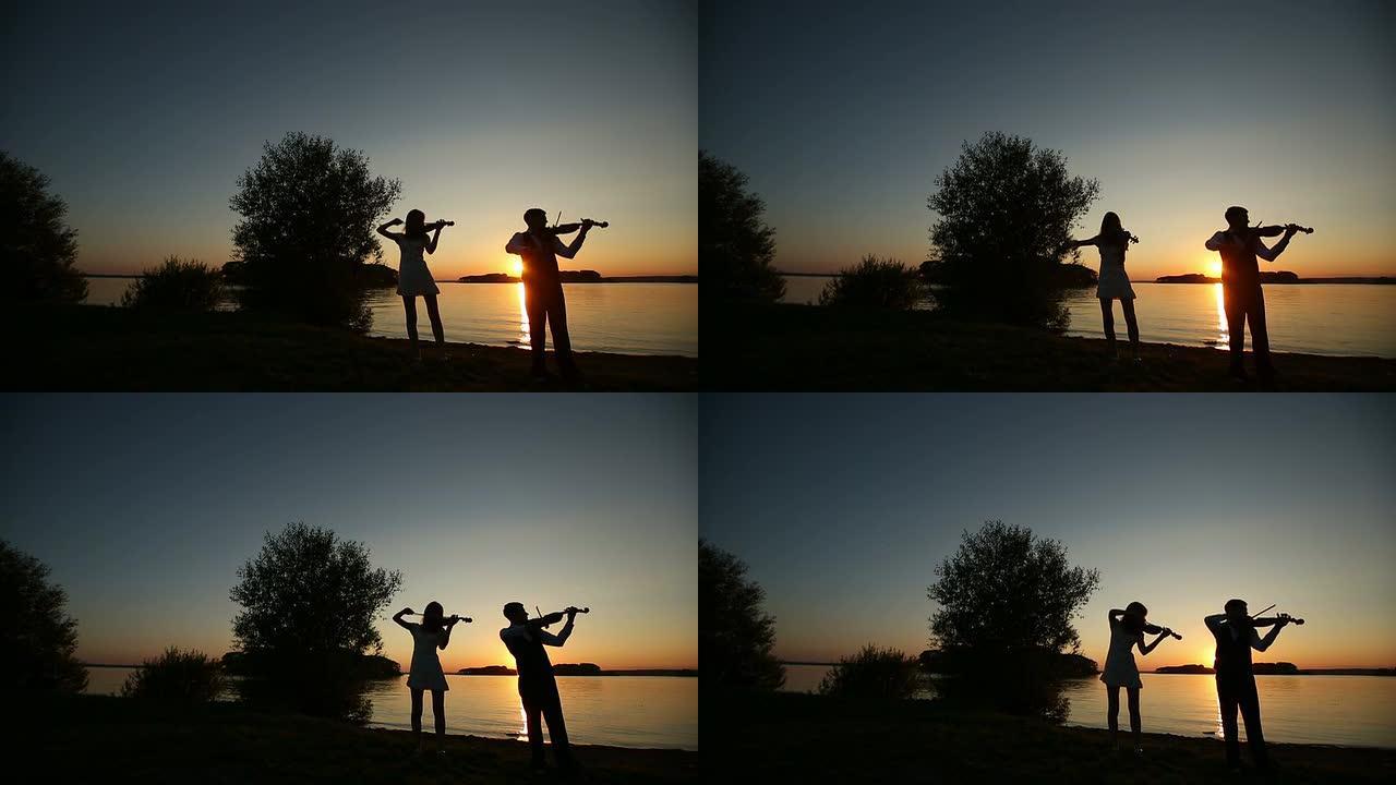 男人和女人在日落时拉小提琴