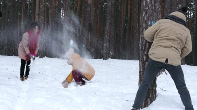 年轻朋友扔雪球，在冬季森林里玩得开心