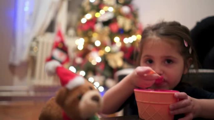 你一岁的孩子在圣诞树旁边吃冰淇淋