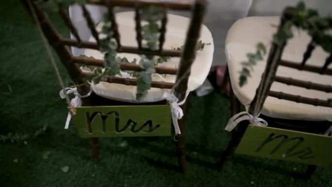 婚礼上的装饰，新娘和新郎的椅子上有标志