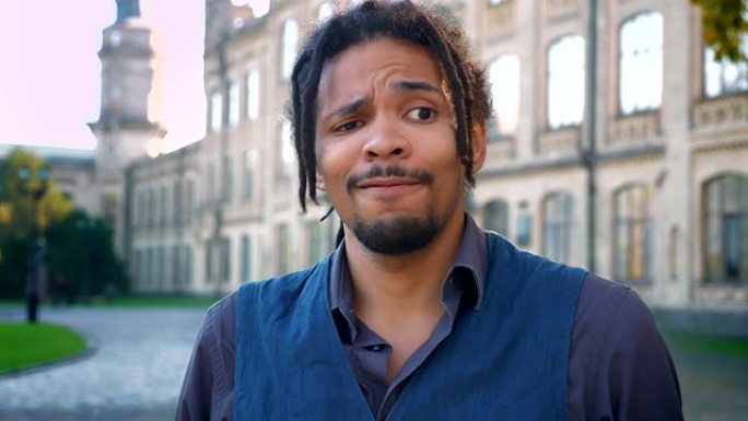 迷人的非裔美国学生的肖像，辫子在大学背景上消极地挥舞着头。
