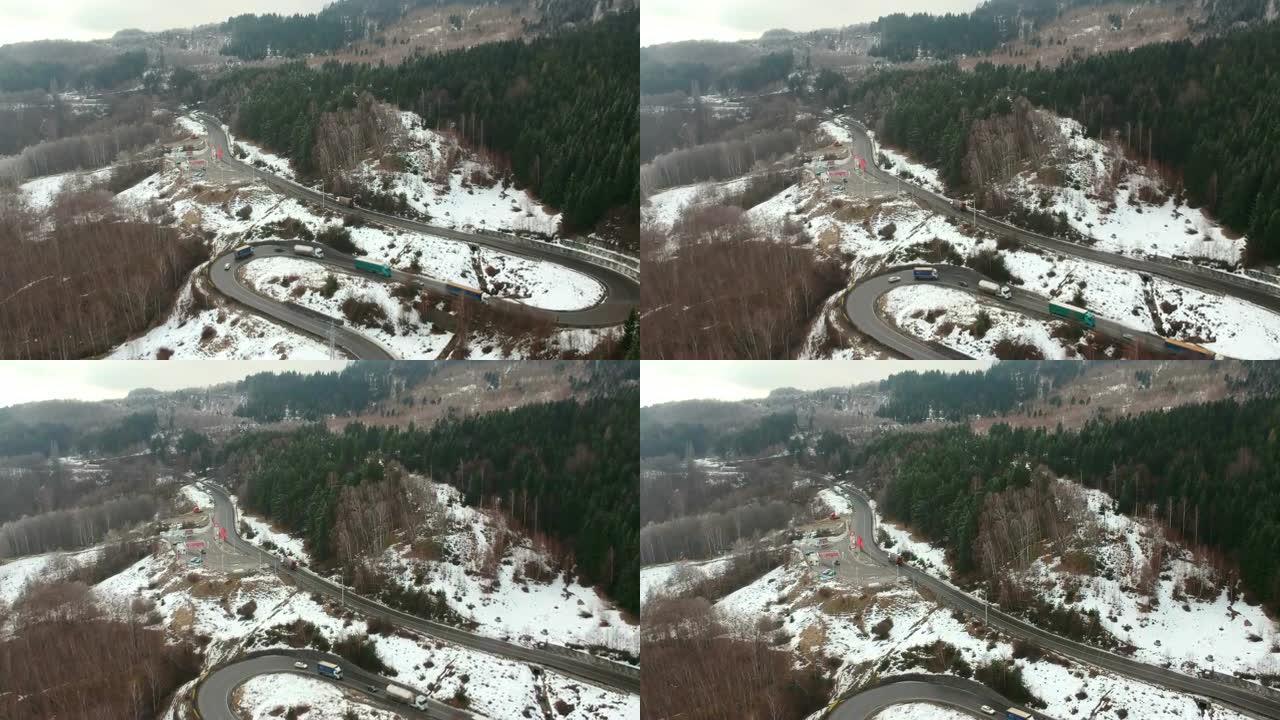 卡车和汽车在罗马尼亚Ciucas山区缓慢穿越危险的弯道和转弯，在冬季条件下，鸟瞰图
