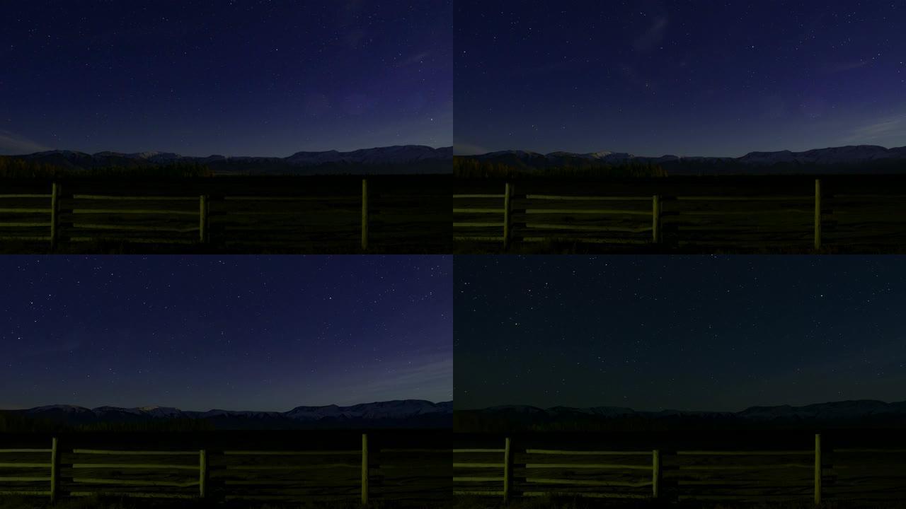 时间圈。星光之夜。前景中的木栅栏，星星在白雪皑皑的山峰上移动