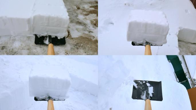 男人从小路上铲雪。暴风雪后用雪铲从人行道上除雪。雪块。