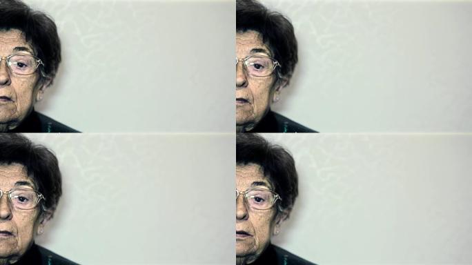 一个悲伤而孤独的老妇人看着相机的肖像 (半脸)