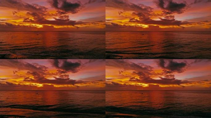 令人惊叹的美丽空中无人机图像，描绘了海洋上空的红色热带日落，两名男子在独木舟上钓鱼