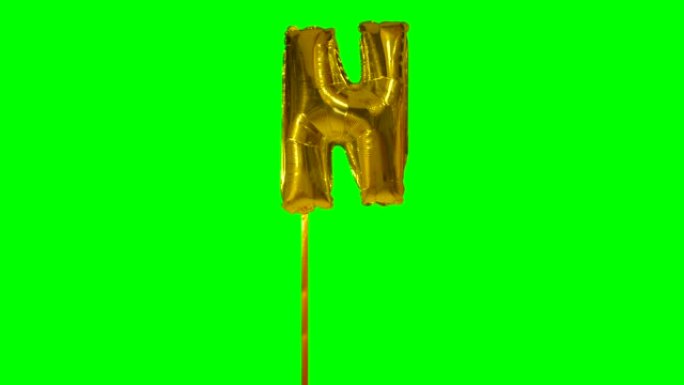 字母N来自漂浮在绿色屏幕上的字母氦气金气球