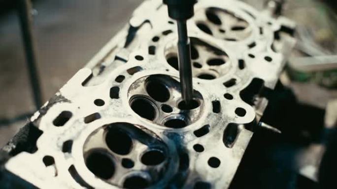 工人机械师在车库车间准备和钻孔用于固定气门头发动机的核心活塞或柱塞。