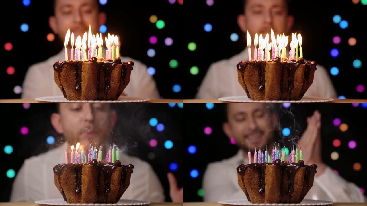 带蜡烛的生日蛋糕。生日男子许愿并吹出五颜六色的蜡烛