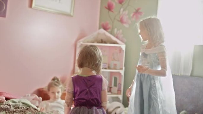 两个穿着公主裙的小女孩一起玩
