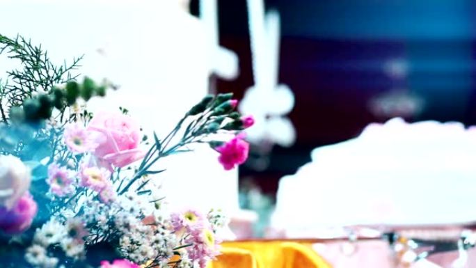 CU Dolly right: 在模糊的婚礼蛋糕背景下为婚礼装饰的一束鲜花。