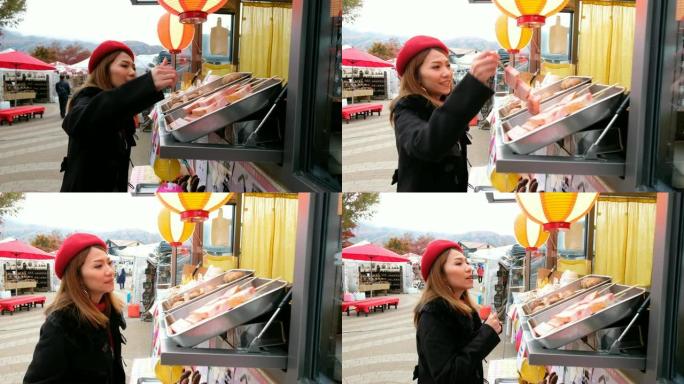 在日本街头市场，一名亚洲妇女从食品卡车上选择烤肉串 (烤猪肉) 的4k移动镜头