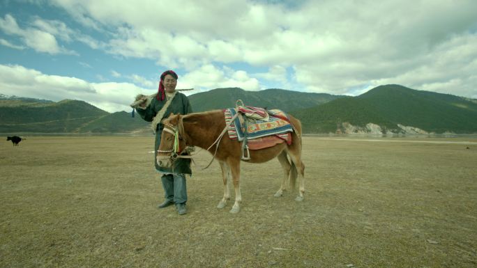 藏族男子牵马微笑