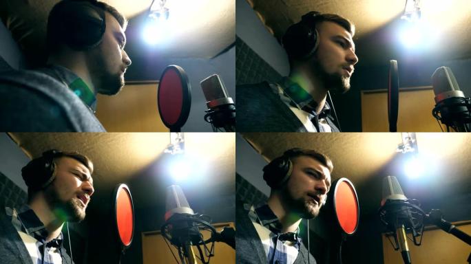 年轻人在情感上录制新的旋律或歌曲。耳机男歌手在sound studio的麦克风中唱歌。创意音乐家的工