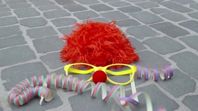 有趣的假发，伪装的眼镜，泡沫材料的鼻子和铺砌的地面上的彩带-狂欢节概念或庆祝概念