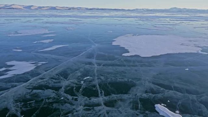 女人在贝加尔湖冰上的旅行。视点视图。去冬日岛旅行。女孩正走在冰石脚下。旅行者看着美丽的冰窟。背包客在
