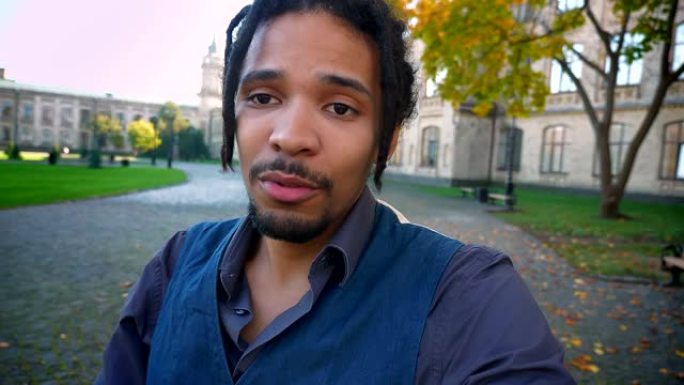 自拍-年轻的非裔美国学生的视频，在大学背景下的视频聊天中，长发lock交谈。