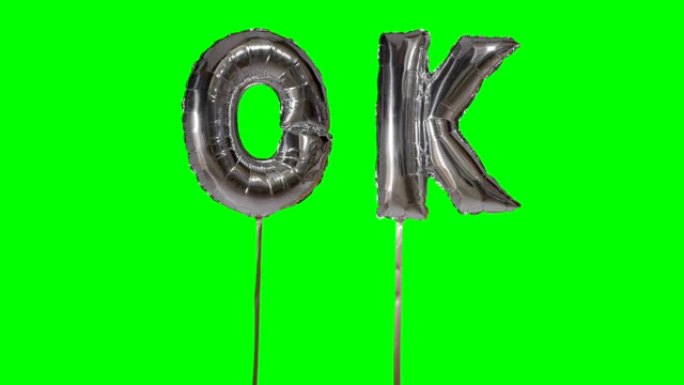 漂浮在绿色屏幕上的氦银气球字母中的单词ok