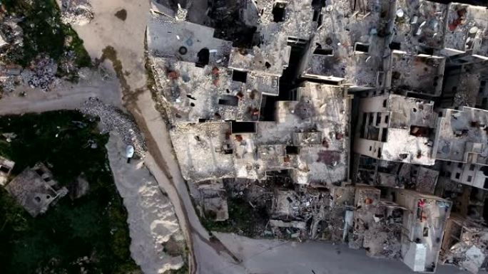 阿勒颇受损房屋的鸟瞰图。一座被轰炸摧毁的城市，只剩下残破的房屋，在蓝天下。