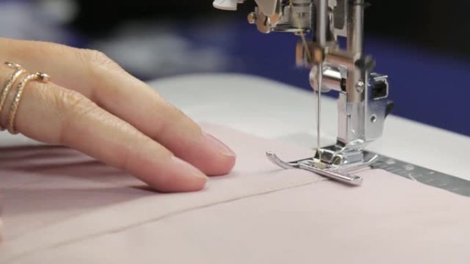 裁缝在缝纫机上缝制内衣，线和花边，手工内衣和衣服，工作过程中的缝纫机，在缝纫工作室工作
