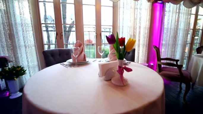 昂贵餐厅装饰精美的宴会桌。鲜花郁金香作为餐厅美丽的餐桌装饰