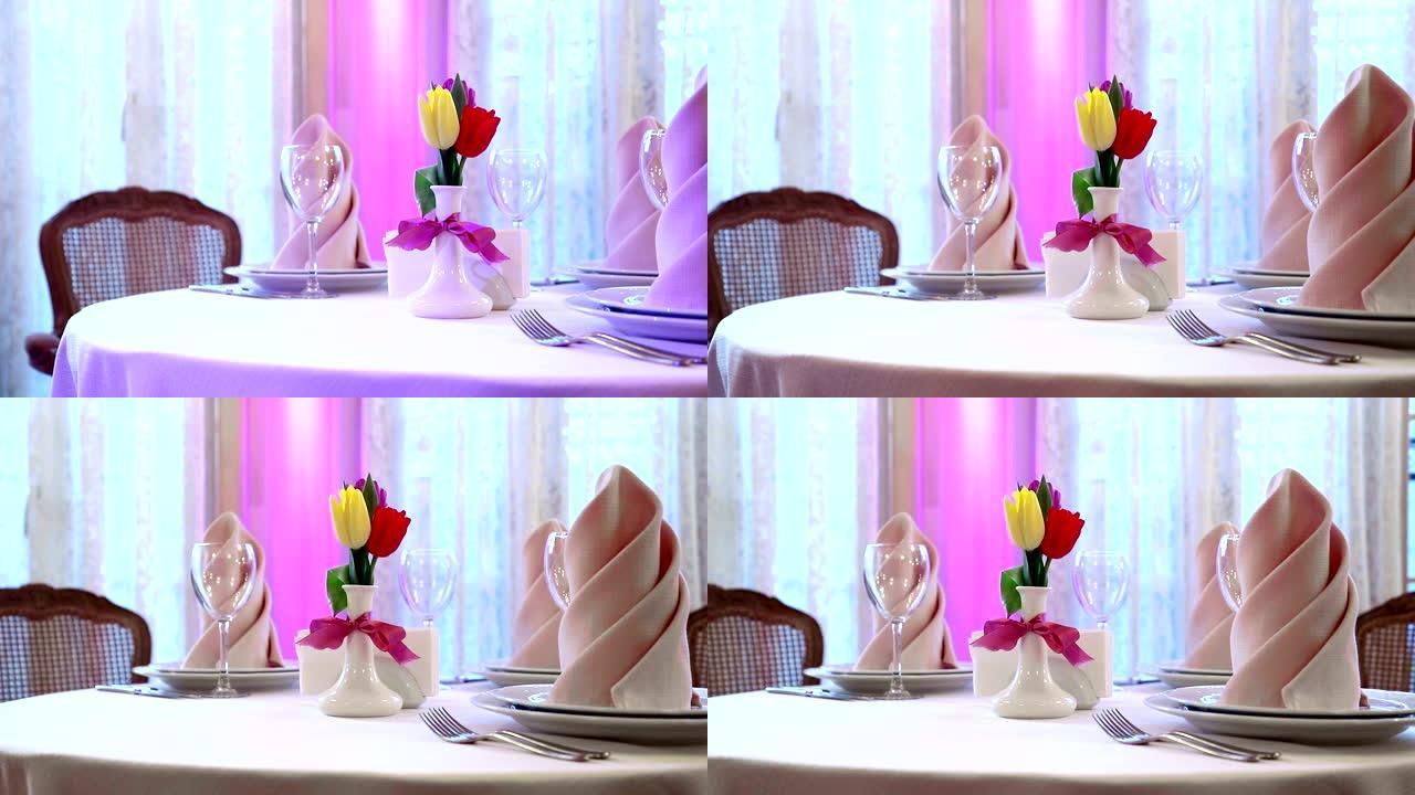 昂贵餐厅装饰精美的宴会桌。鲜花郁金香作为餐厅美丽的餐桌装饰