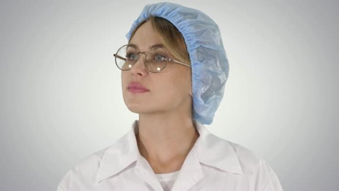 戴着眼镜和帽子的女医生在渐变背景上行走和环顾四周
