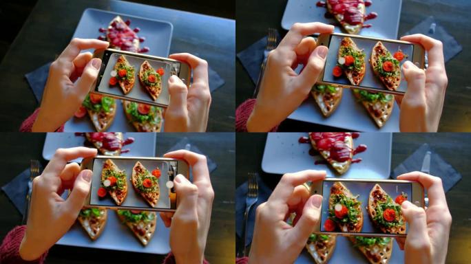 俯视图-女人的手使用智能手机拍摄美味的食物。4k。新鲜漂亮的华夫饼配菠菜、樱桃番茄和辣梨甜点。