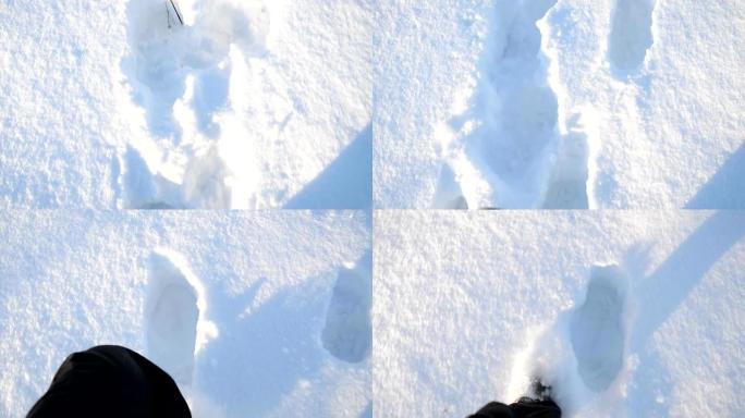 穿着靴子的人的脚在深雪上行走