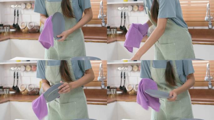 女性在家庭厨房用洗碗巾手清洁餐具，生活方式