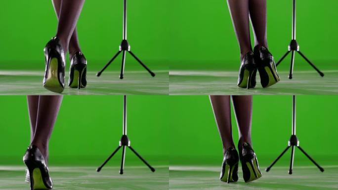 女人的腿。带麦克风支架的女艺术家。在绿色屏幕上唱歌。慢动作。在红色史诗电影相机上拍摄。
