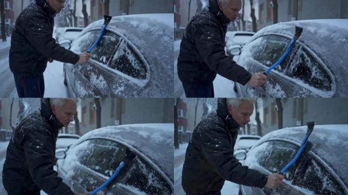 穿着冬季夹克的老人在屋前的停车场上清洁汽车