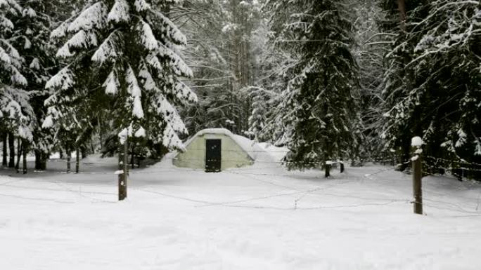 冬季森林中被铁丝网包围的小型军用旧地堡