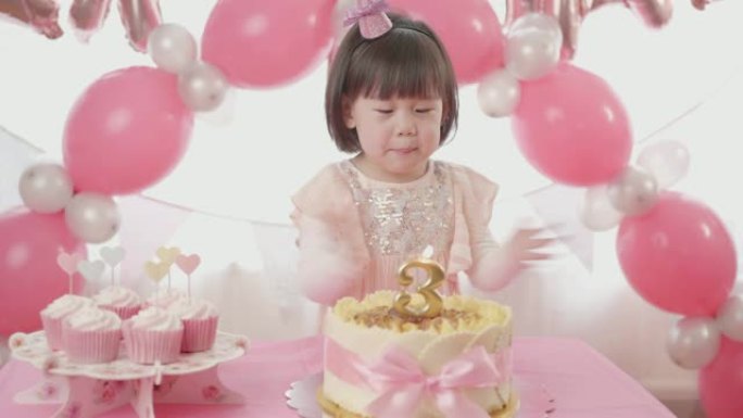 蹒跚学步的女孩在家庆祝她的三岁生日